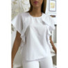 Blouse blanche à volant avec trois boutons à l'épaules