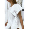 Blouse blanche à volant avec trois boutons à l'épaules