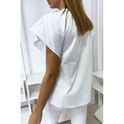 Blouse blanche à volant avec trois boutons à l'épaules